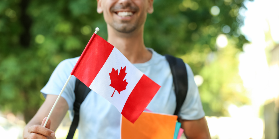 A happy immigrant holding a Canadian flag, representing the pathways to Canada through Startup Visa vs Express Entry/PNP.