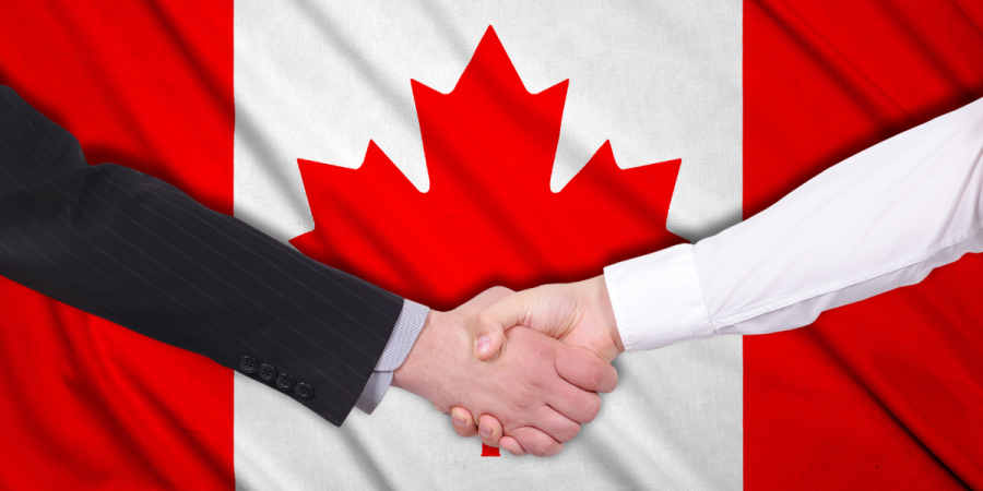 a handshake between two business professionals in front of the canadian flag, representing opportunities for starting a business in canada before pr.