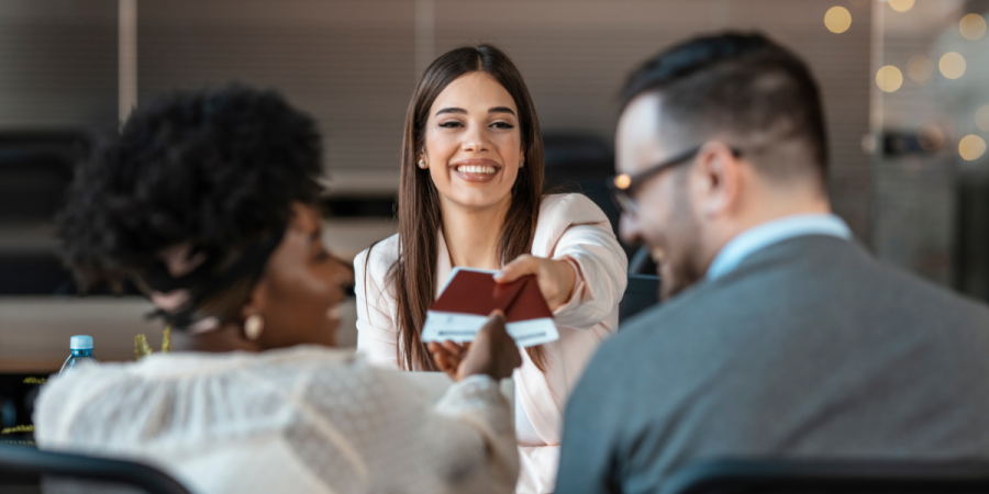 A consultant handing passports to a happy couple, symbolizing Canada Shaws Consulting’s expertise in Startup Visa vs Express Entry/PNP immigration services.