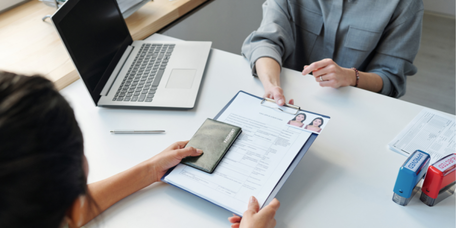 Applicants submitting documents for the Canada Startup Visa Processing Time, including a passport and application form, during the visa approval process.