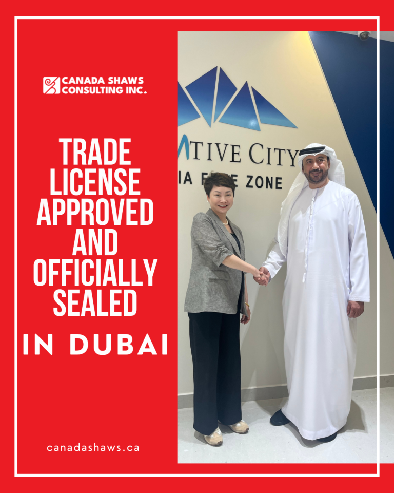 Cellia Xiao, representing Canada Shaws Consulting Inc., stands shaking hands with an Emirati official at the Creative City Media Free Zone in Dubai. The image celebrates the approval and official sealing of a trade license. The backdrop features the logo of Creative City Media Free Zone, with bold red branding around the photo and text announcing the milestone.