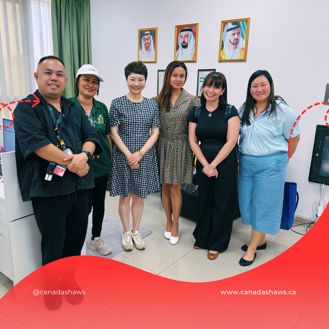 “Group photo at Ace-Gen International. Six representatives from Canada Shaws and the partner institution stand smiling in an office setting. Portraits of UAE leaders are framed on the wall behind them.”