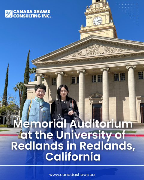 Two women standing in front of the Memorial Auditorium at the University of Redlands in Redlands, California, under a clear blue sky.