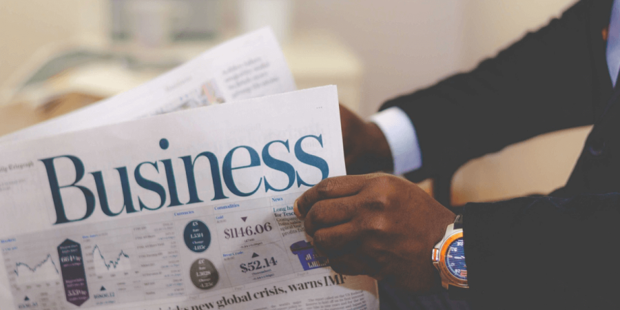 A businessman reading a financial newspaper, representing research, planning, and the best businesses to start in Canada.
