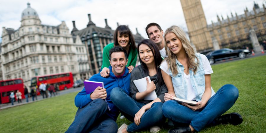 happy international students sitting on grass after resolving canada study permit refusal