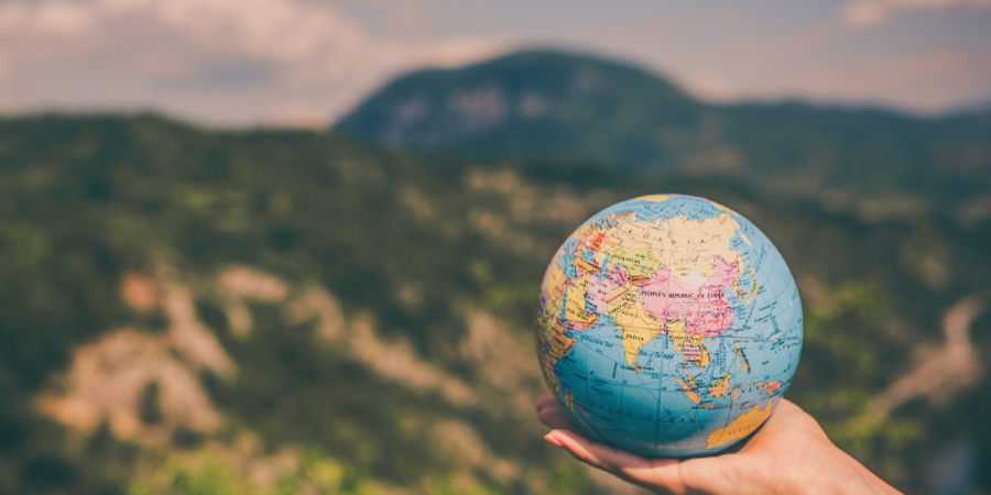Hand holding globe of the world best countries to study abroad