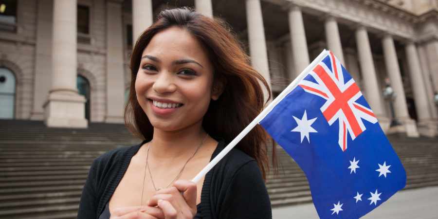 woman smiling with australia flag best countries to study abroad