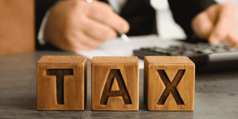 immigration myths about taxes explained with wooden tax blocks on desk