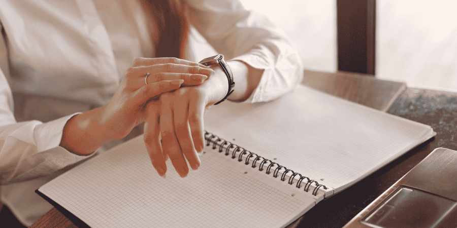 woman checking watch during meeting showing time management in work culture
