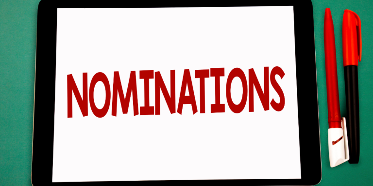 tablet displaying the word 'NOMINATIONS' with pens, symbolizing provincial nominee program