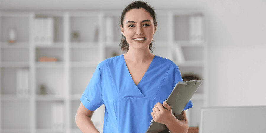 female nurse smiling and holding clipboard representing healthcare jobs opportunities