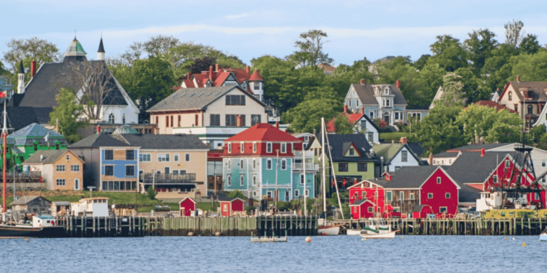 colorful houses by the water representing affordable coastal cities in Canada